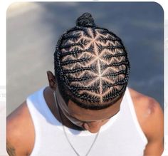 a man with long braids on top of his head looking down at the ground