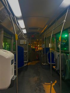 the inside of a public transit bus with its lights on and no people in it