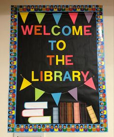 a welcome to the library sign with books and flags hanging from it's sides