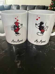 two coffee mugs sitting on top of a table