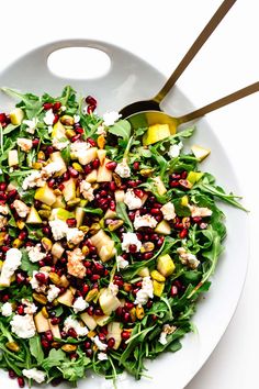 a white plate topped with a salad covered in feta cheese and pomegranate