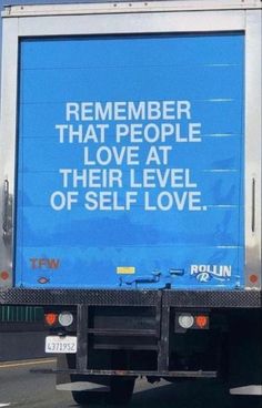 a blue truck driving down the road with a message on it's back window