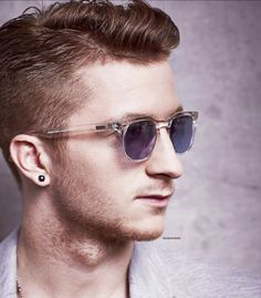 a young man wearing sunglasses and a necklace