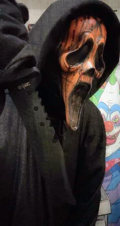 a person in a black hoodie with a mask on