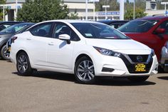 a white car parked in a parking lot next to other cars