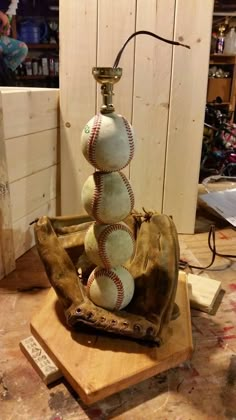 a lamp made out of baseballs sitting on top of a wooden base in a room