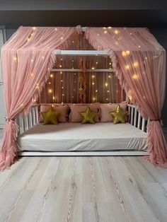 a bed with pink curtains and stars on it