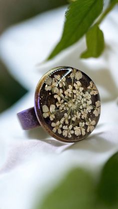 Welcoming a little piece of nature for someone unerring! Enjoy this pressed Queen Anne's Lace Ring pressed before encapsulating them with resin. Ring Measures, Tray: 16mm, 5x17mm Pendant Measures: Oval Tray: 25x18mm, 42.5x23.5x2mm, Hole: 3mm The Antique Bronze ring is adjustable and comes in a beautifulgift box.. All Jewelry findings are Lead and Nickel free. The petals have been carefully preserved to retain their color and would make a great gift for your loved ones. This piece was made with r Nature-inspired Gold Flower Ring With Birth Flower, Nature-inspired Gold Birth Flower Ring, Handmade Gold Flower Ring Nature-inspired, Handmade Gold Flower Ring, Nature-inspired, Nature-inspired Brass Rings For Gifts, Bohemian Brown Flower Jewelry, Brown Flower-shaped Jewelry Gift, Handmade Brown Flower Jewelry, Vintage Flower Shaped Rings For Gift