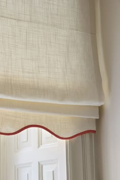 an open window with a white curtain and red trim on the bottom half of it