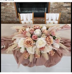 a bouquet of flowers is sitting on a table in front of a fire place and chairs