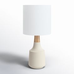 a white table lamp with a wooden base and a white shade on the top of it