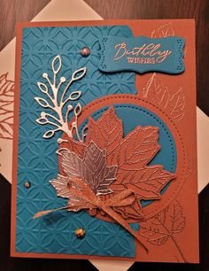 a blue and orange birthday card with an autumn leaf on the front, and a gold foiled design on the back