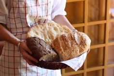 a person holding a basket with bread in it