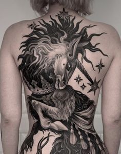 the back of a woman's body with a unicorn tattoo on her upper half