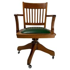 a wooden desk chair with green leather seat