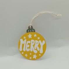 a merry ornament hanging from a string