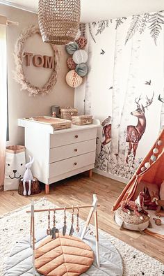 a child's room with a teepee tent and deer wallpaper