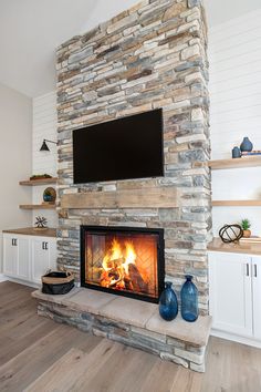 a stone fireplace with a flat screen tv above it