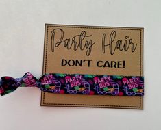 a hair tie with the words party hair don't care written on it and colorful bows