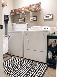 a washer and dryer in a laundry room with black and white rugs