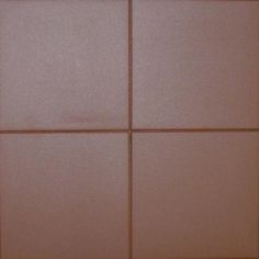 a white toilet sitting next to a brown tiled wall