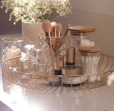 various beauty products are sitting on a table next to a vase with flowers in it