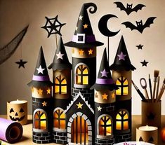 a castle made out of paper with bats and stars on it, surrounded by other halloween decorations