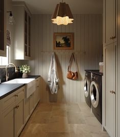 a washer and dryer in a room with wood paneling on the walls