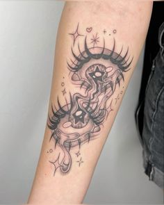 a woman's arm with a black and white tattoo design on the left forearm