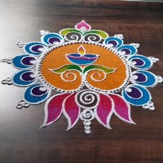 an artistic design made out of colored paper on top of a wooden table with beads