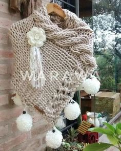 a white pom pom hanging from the side of a brick wall next to a window