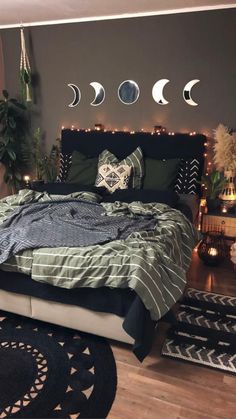 a bed room with a neatly made bed and several hanging moon phases on the wall