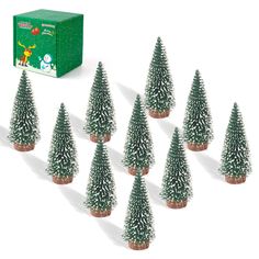 small christmas trees are lined up in front of a box