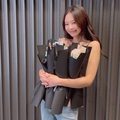 a young woman is holding several pieces of black paper