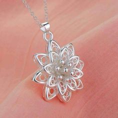 A delicate and sacred symbol, Sacred Lotus Flower Necklace features intricate milgrain bead and openwork detail. The 3D flower is impressive with it's realistic center and stems in gleaming sterling silver. at 1.25 inch in diameter, it makes a shiny silver statement. Includes 18 in. chain. Material: 925 sterling silver plated over copper Size: 3.2cm (1.25 inch) Complimentary gift box. (Reg $49.95) Delicate Silver Jewelry With Flower Decoration, Delicate Flower Pendant Jewelry With Flower Decoration, Silver Jewelry With Flower Decoration For Gift, Delicate Filigree Flower Jewelry, Elegant Silver Flower Necklace With Decoration, Elegant Silver Flower Decoration Necklace, Filigree Flower-shaped Necklace For Gift, Silver Flower Shaped Jewelry With Intricate Design, Silver Flower-shaped Jewelry With Intricate Design