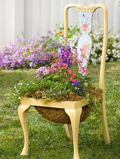 an old chair with flowers growing in it