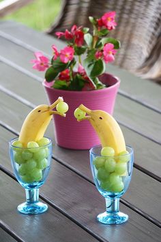 two glasses with grapes and bananas in them