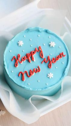 a blue cake with the words happy new year written in red frosting on it