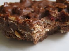 two pieces of chocolate and nuts bar on top of each other with one bite taken out