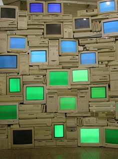 there are many old tvs stacked on top of each other with green screens all over them