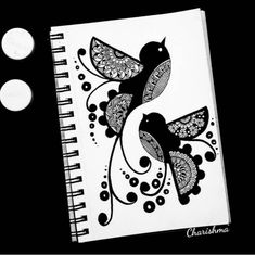 a black and white drawing of two birds on top of a spiral notebook with circles around it