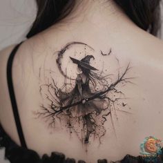 the back of a woman's shoulder with a black and white image of a witch on