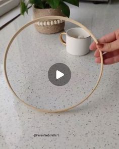 someone is holding a wooden hoop around a coffee cup