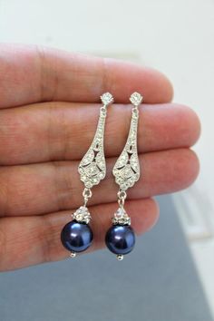 a pair of earrings is shown in the palm of a person's hand,