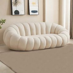 a white couch sitting on top of a rug in a living room next to a window