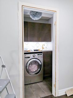 a washer and dryer in a small room next to a stepladder