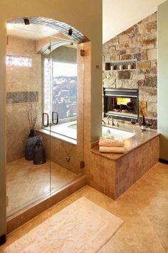 a bathroom with a stone fireplace in the corner and glass doors on the outside wall