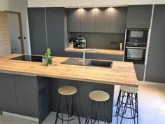 a kitchen with two stools next to an island