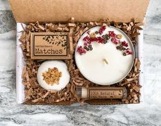 an open box containing a candle, soap and nuts