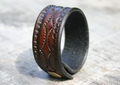 "Here is a leather bracelet that is tan with black faded edges.  This unisex leather wrist cuff features a custom tooled design and will be custom made for your wrist. It is just over 1\" wide and is held on with a matching brass snap! Each bracelet is custom made for each order.  So please be sure to select your personal wrist size, and I will make sure the bracelet fits you as you wish. The leather is an excellent durable vegetable tanned leather, that is approx 1/8\" thick. If you have any qu Adjustable Stamped Leather Cuff Bracelet, Brown Stamped Cuff Bracelets, Brown Stamped Cuff Bracelet, Vintage Adjustable Cuff Bracelet In Distressed Brown, Rugged Adjustable Cuff Leather Bracelet, Adjustable Hand Tooled Cuff Bracelet, Adjustable Vintage Cuff Bracelet In Distressed Brown, Adjustable Vintage Distressed Brown Cuff Bracelet, Vintage Distressed Brown Adjustable Cuff Bracelet